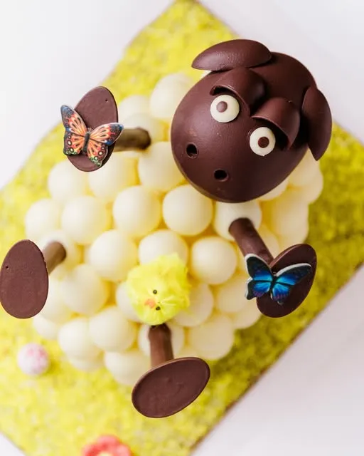 Oveja de chocolate con bolitas blancas y mariposas