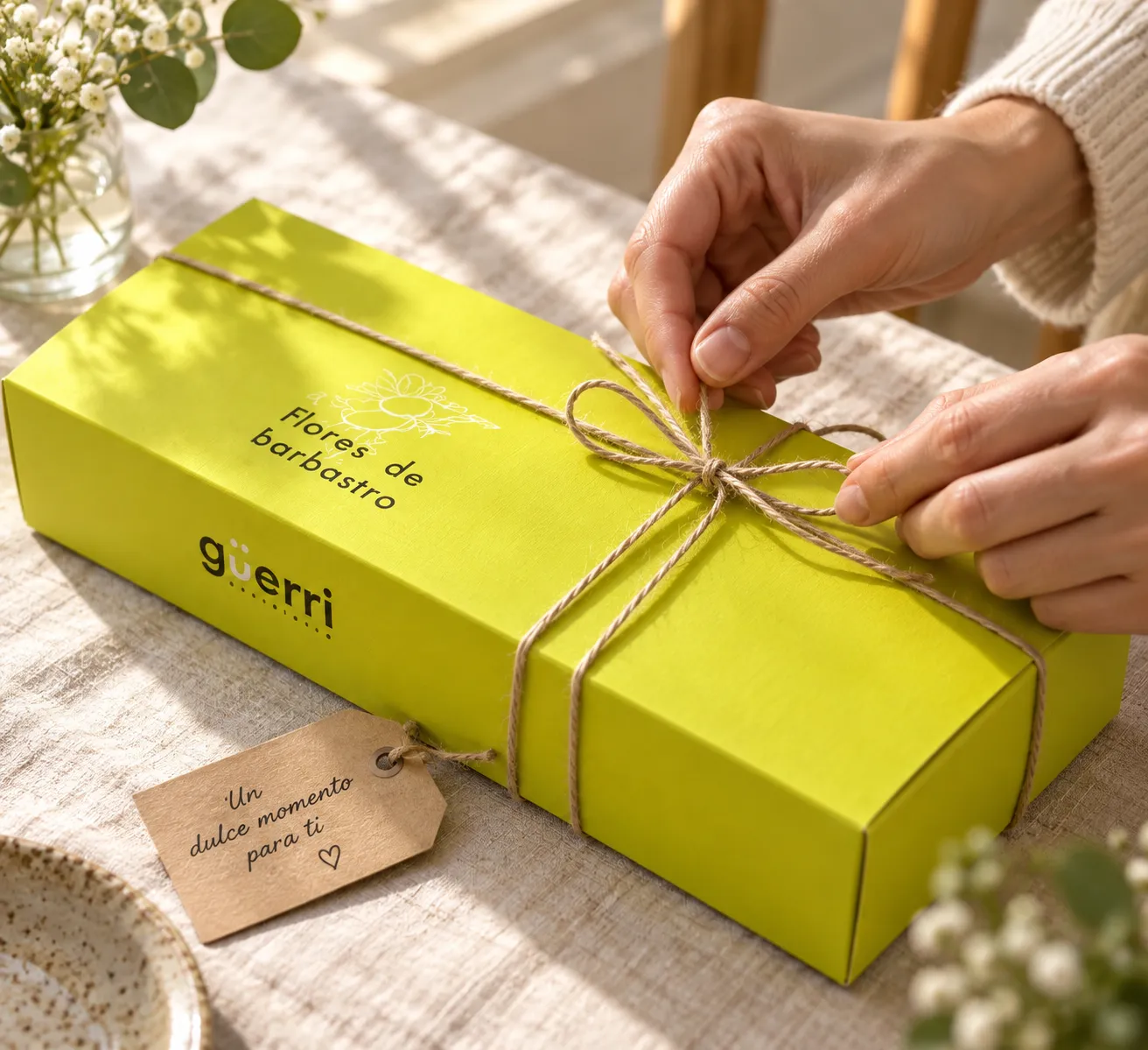 Unas manos atando con cordel una caja lima de Flores de Barbastro para regalar